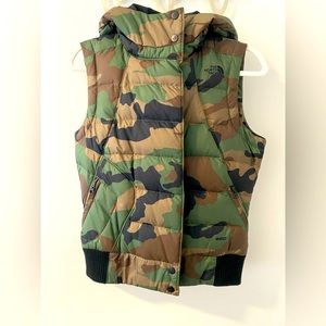 The North Face Women’s Camo Puffer vest with hood and zipper pockets.